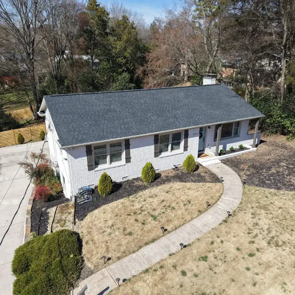 Charlotte roof replacement project showing a dark shingle roof on a brick home.
